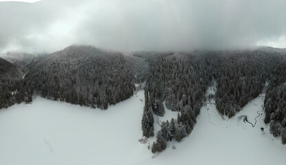 Aerial view. Frozen alpine lake. Covered in snow. High snowfall this winter. widescreen panorama of...