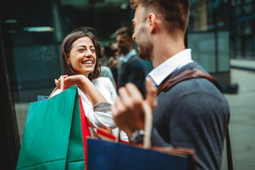 Sale, travel love consumerism and people concept. Happy couple with shopping bags in the city