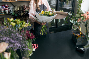 Photo of florist holding beautiful flowers in flower shop, copy space. Lifestyle flower shop. Beautiful flower composition