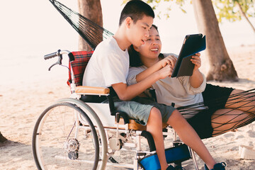 Special need child on wheelchair use a tablet in the house with his parent, Study or Work at home...