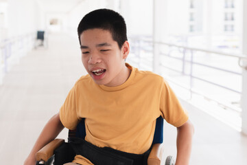 Asian special child on wheelchair is smiling face as happiness on ramp for disabled people background in hospital, Lifestyle in the education age of disabled children, Happy disability kid concept.