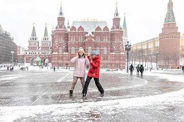 A beautiful young girls walks along Manezhnaya Square in Moscow during a snowfall and blizzard