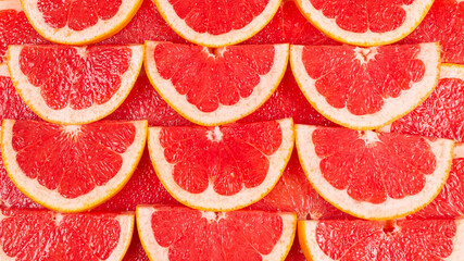 Grapefruit red juicy slices background. top view.