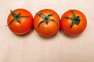 Three fresh red tomatoes on a light background. Healthy food concept