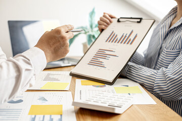 The male employee is explaining information from the company's financial documents to the manager...