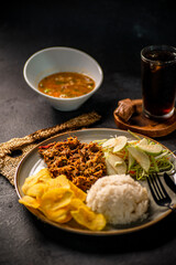 plato de carne arroz tajadas de platano ensadala con caldo y refresco de cola
