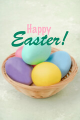 colorful easter eggs in a basket on green background