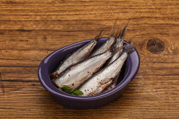 Anchovies in the bowl served basil leaves