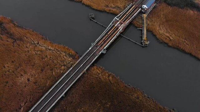 Aerial - Railroad bridge over river in Somerleyton, England, wide shot above