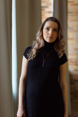 Thoughtful pregnant woman caressing her belly