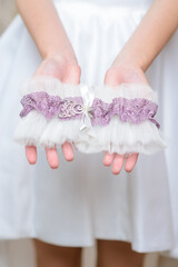 Bride in a white dress is holding a beautiful bright bridal bouquet.