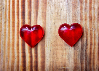 Valentines day background with two red hearts on wooden background..