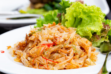 Pomelo salad on spoon or Thai Yum Som O on white plate, closed up