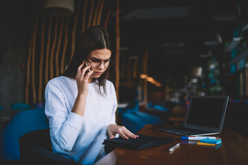 Serious woman using smartphone for making call