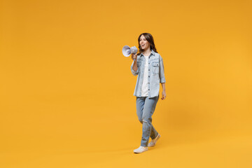 Fototapeta na wymiar Full length of young excited expressive brunette fun happy woman 20s in stylish casual denim shirt white t-shirt screaming hot news shouting in megaphone isolated on yellow background studio portrait
