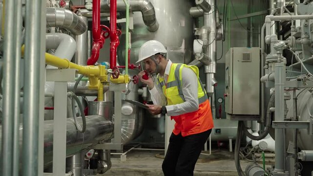 nspector, Engineer Or the foreman is checking the valve and pipelines in the boiler room in the factory.
