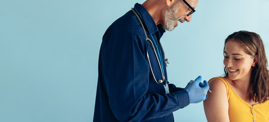 Woman receiving vaccination from a doctor