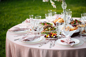 Decorated outdoors nature banquet table set with candles and dried flowers