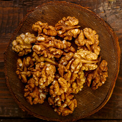 A handful of nuts are scattered on a board on a wooden table.