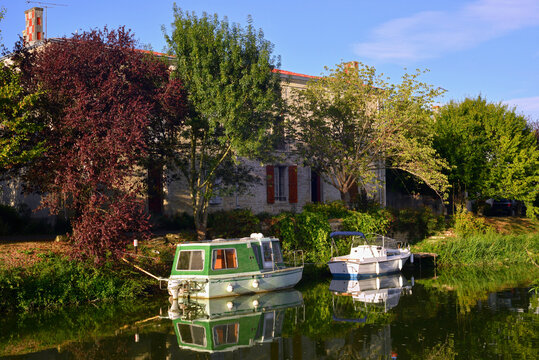 Deux bateaux sur la S&egrave;vre Nortaise au soleil couchant &agrave; Damvix (85420), d&eacute;partement de Vend&eacute;e en r&eacute;gion Pays de la Loire, France