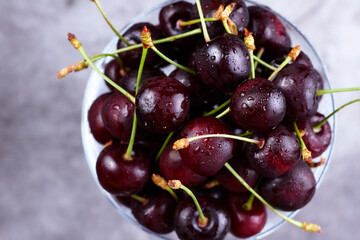 Fresh cherries in glass on a dark background. Top view