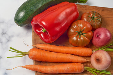 Various greens and vegetables on wooden kitchen table