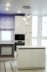 Stylish kitchen interior with white facades and built-in appliances.