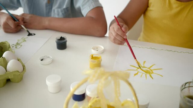 Cgildren drawing together on Easter in a white room