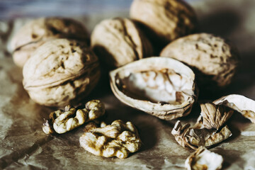 Fototapeta na wymiar Cerneaux de noix et coquilles de noix posés sur la table de la cuisine - Ouvrir les noix fraîches