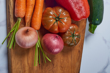 Various greens and vegetables on wooden kitchen table