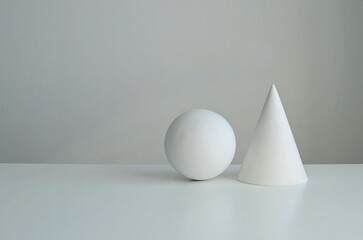 The geometric shapes of the ball  and  cone on white background, copy space