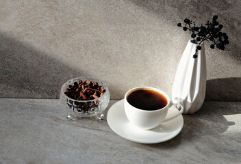 White  cup of coffee, vase, chocolate curls on grey marble background, copy space.