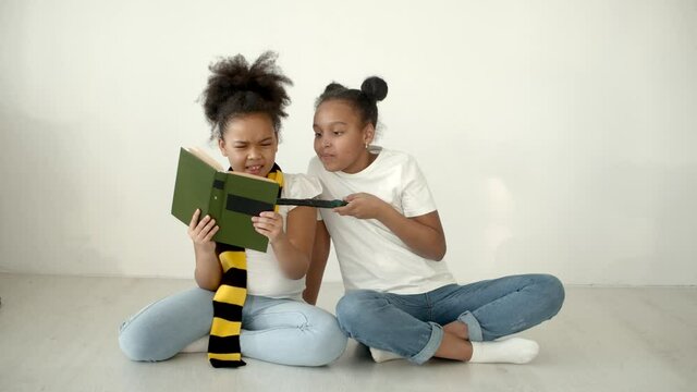 African american girls reading a book and holding magic wand