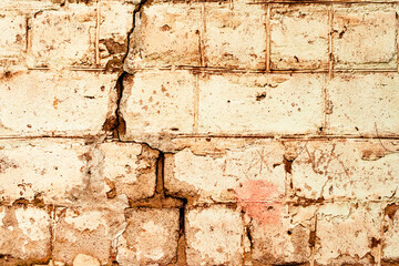 Texture of a brick wall with cracks and scratches which can be used as a background