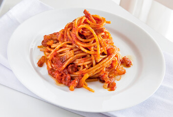 Plate of spaghetti with tomato and bacon