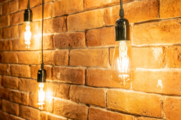 Decorative incandescent bulbs in Edison style on a brick wall background