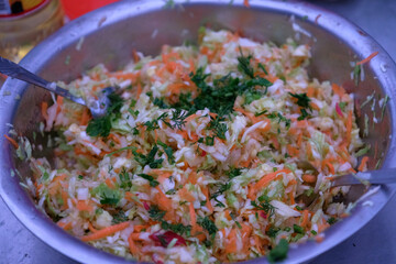 Camping. In a metal bowl, finely chopped salad of cabbage, carrots, herbs.