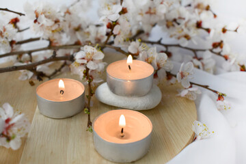 Springtime aromatherapy composition with burning candles and cherry blossom. Romantic concept for wedding, Mothers day or resort.