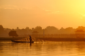 Local fishermen in Taung Tha Man lake near U Bein bridge in early morning at sunrise. Mandalay, Myanmar (Burma).