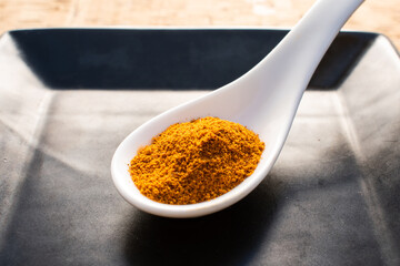 turmeric in a white ceramic spoon on a black plate, cork background

turmeric in a white ceramic spoon on a black plate, cork background