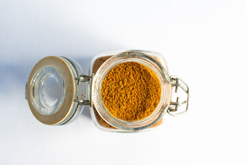 turmeric in a small spice jar open isolated, top view