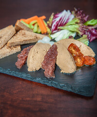 Fresh homemade liver pate with bread, sun-dried tomatoes and vegetables
