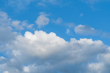 Bright blue sky with white fluffy clouds and bright sunlight.