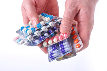 Close-up of hand holding medication blister packs of tablets and capsules against .Colorful pills and medicines in the hand.Medicine and healthcare concept
