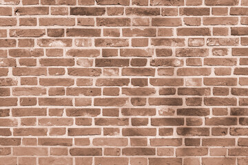 A wall of old, cracked bricks, with a weathered and faded surface. Restored brickwork of an old house.