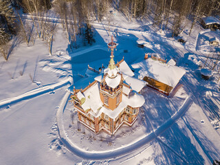 Aerial view to old traditional russian wooden house ("Astashovo terem") with ornamental carved windows, frames, turrets near Chukhloma, Kostroma region, Russia. Kostroma landmark from drone.