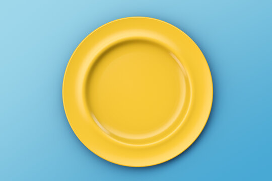 Yellow empty plate on a blue table. Looks like the sun in the sky. Top view