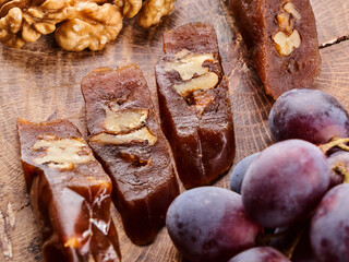 Churchkhela, national Georgian dessert made from grape juice and walnuts, composition on a wooden table