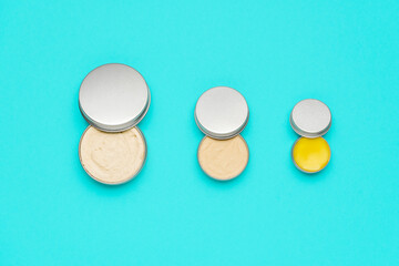 Natural cosmetics in metal cans, isolated on a blue background.