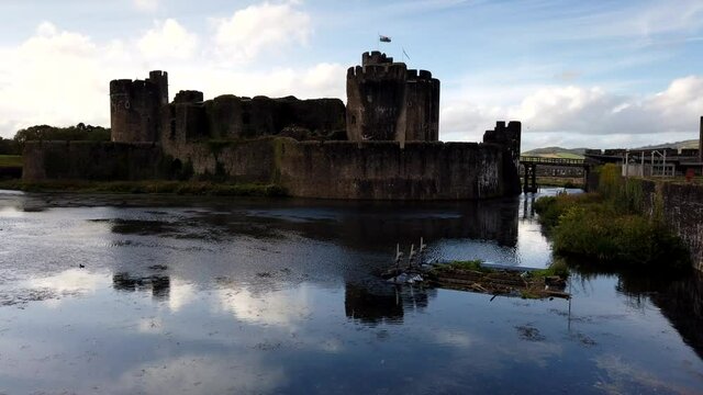 Time lapse shot of Caerphilly Castle during sunlight and clouds,surrounded by water ditch.